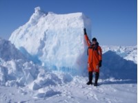 Mann foran stort havisflak som ligger oppå annet isflak